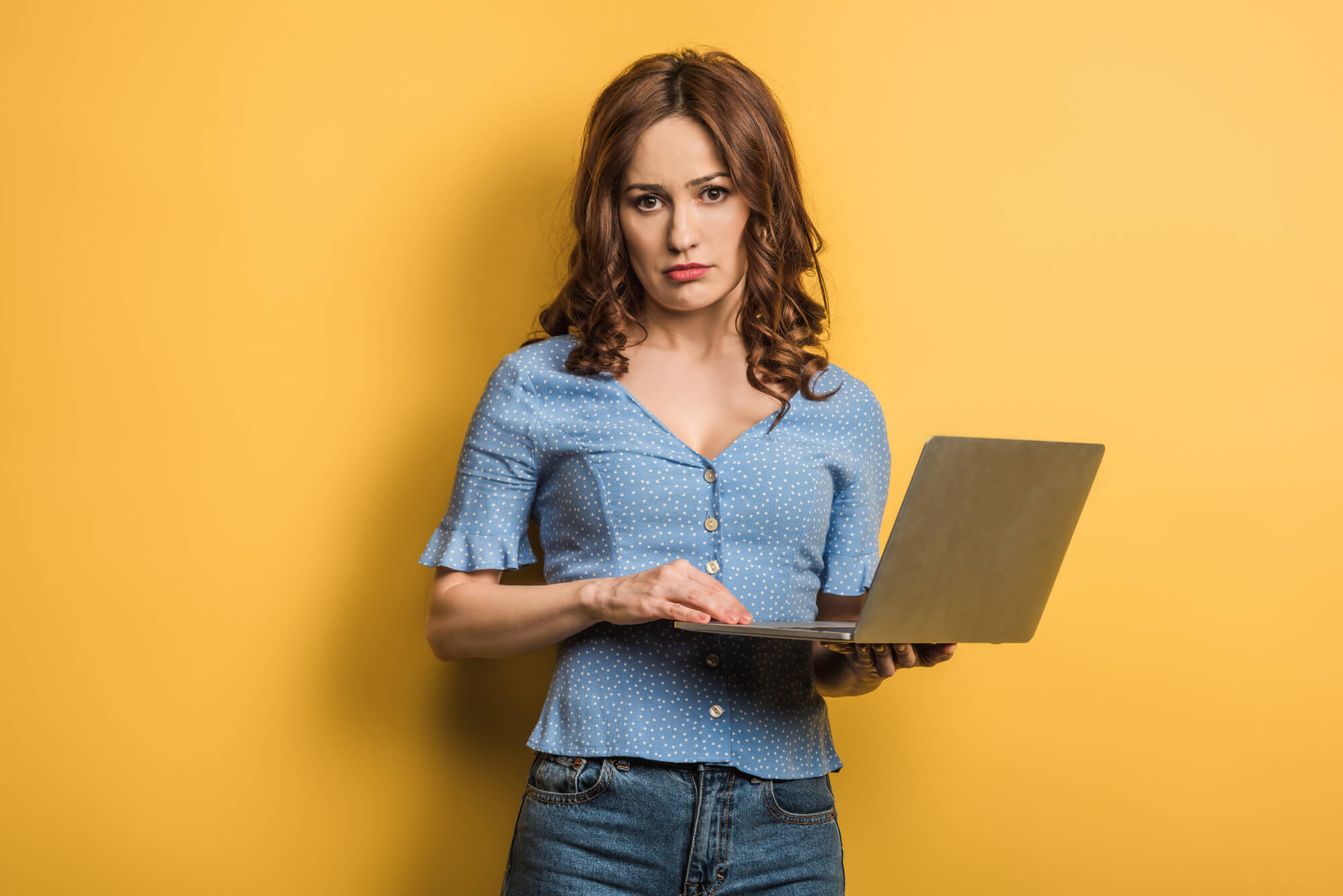 displeased female holding a laptop
