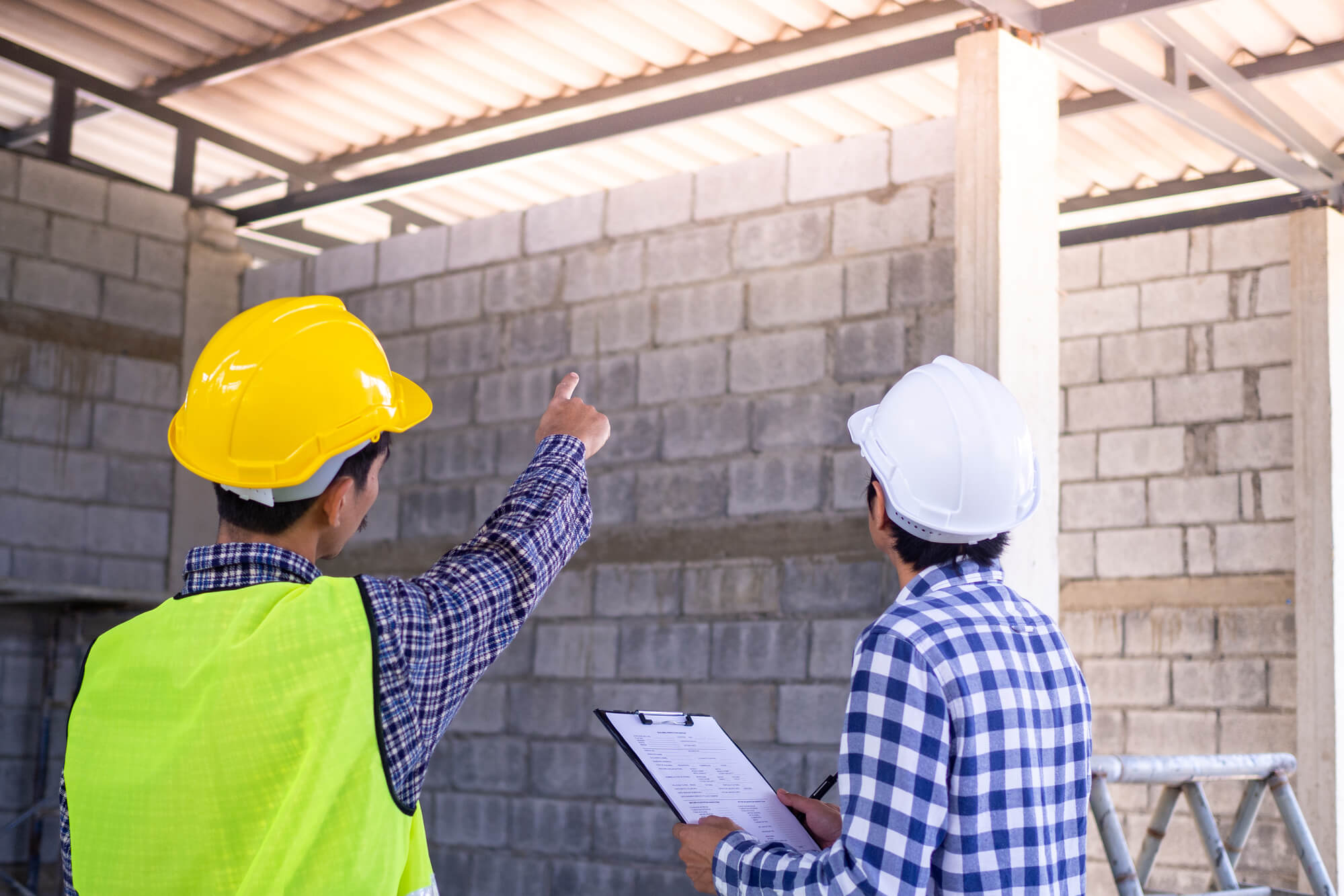 two contractors looking at wall