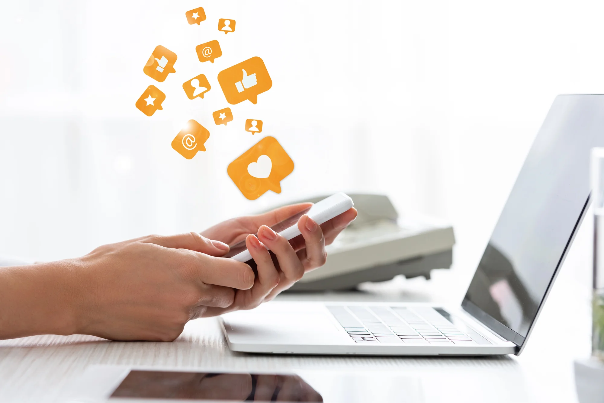 Hand holding a smartphone with likes, comments, and star icons illustrating social media management services