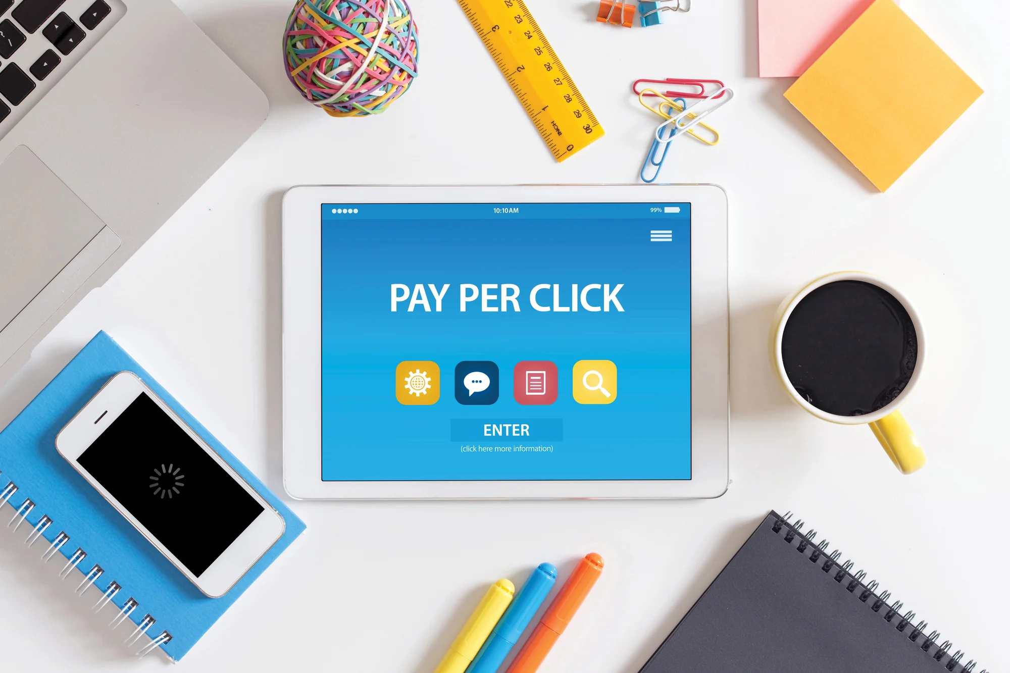 Tablet on a desk displaying a Pay Per Click screen surrounded by office supplies, representing PPC for dentists