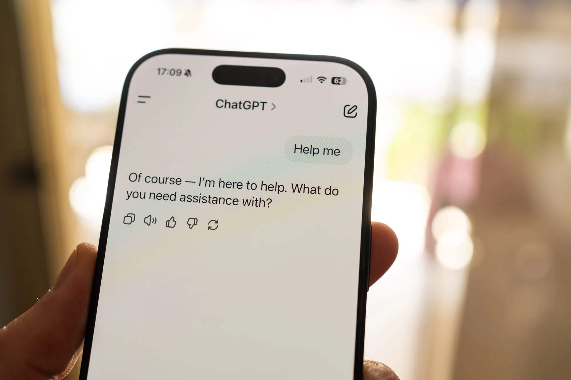 Hand holding a smartphone with the ChatGPT app answering a help request, showing how users get brand recommendations that LLM optimization targets