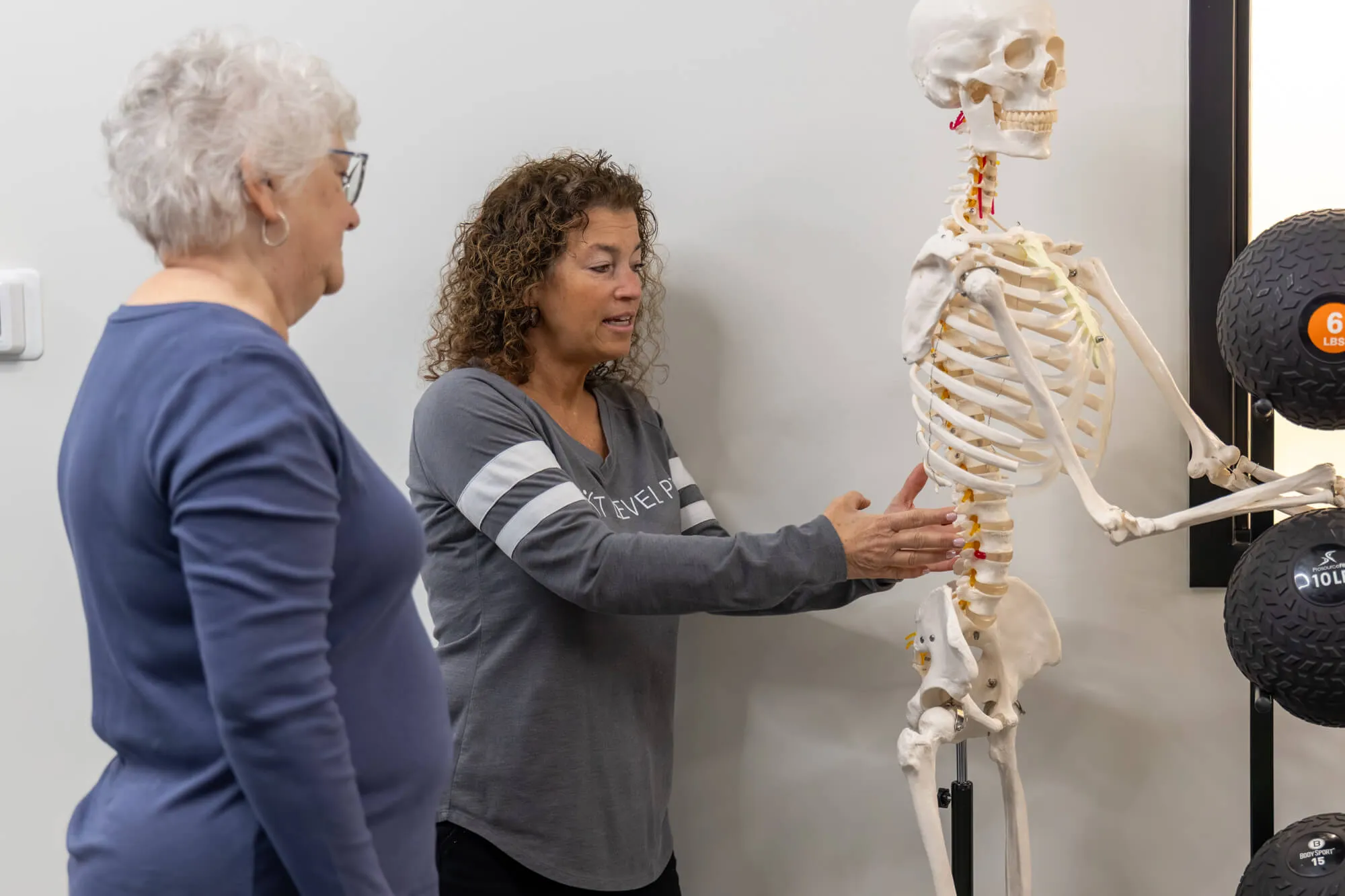 Dr. Gina Croft explaining anatomy to a patient at Next Level PT physical therapy Westlake.