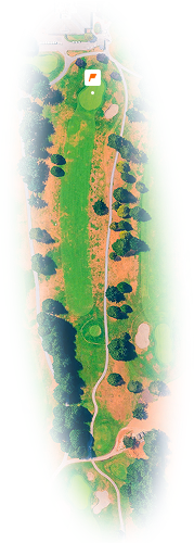 Aerial view of a golf hole with a fairway, green, bunkers, trees, and a flag on the green.