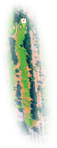 Aerial view of a golf course hole with fairways, greens, sand traps, trees, and adjacent road.