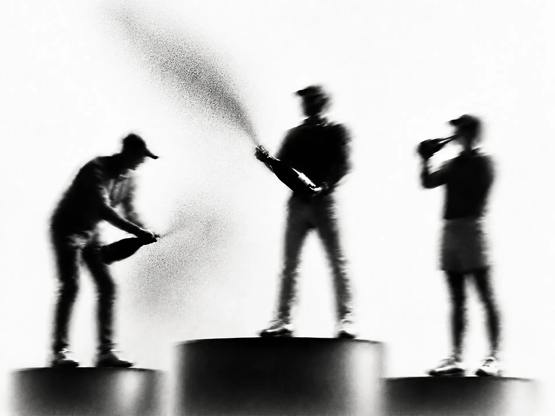 Blurry black and white silhouettes of three people on podiums spraying and drinking champagne.
