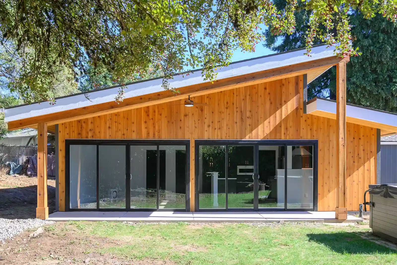 Modern ADU with large black-framed sliding glass doors and a slanted roof.