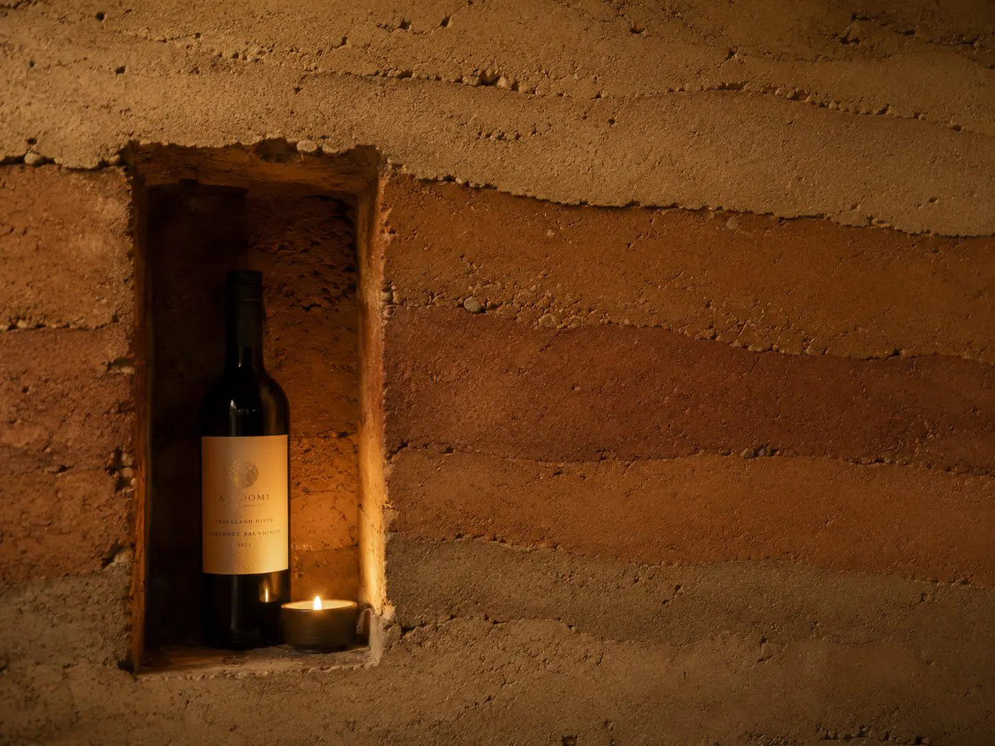 Compacted earth wall with concave for displaying wine
