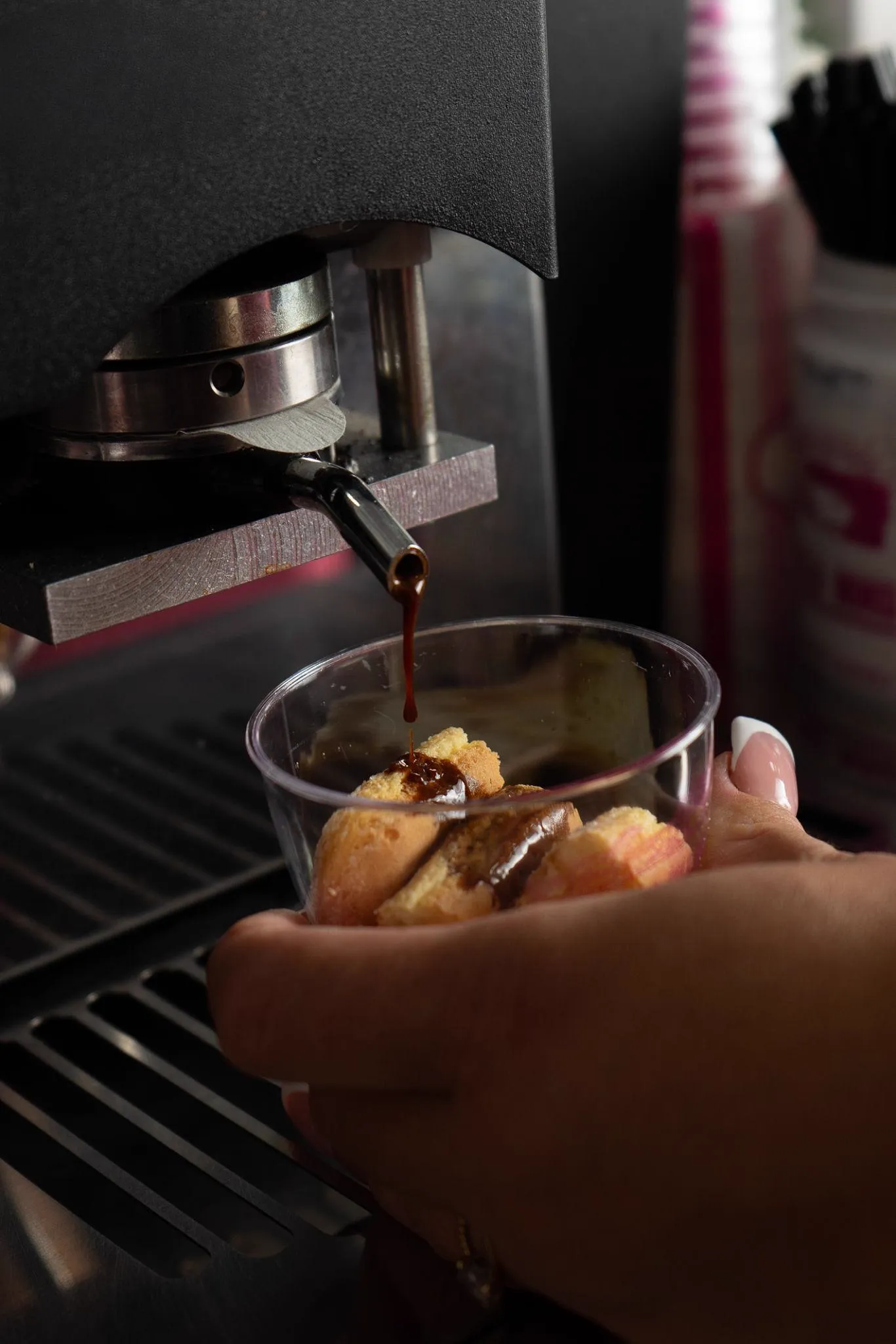 Café espresso incorporándose al bizcocho de una tarta de tiramisú artesanal
