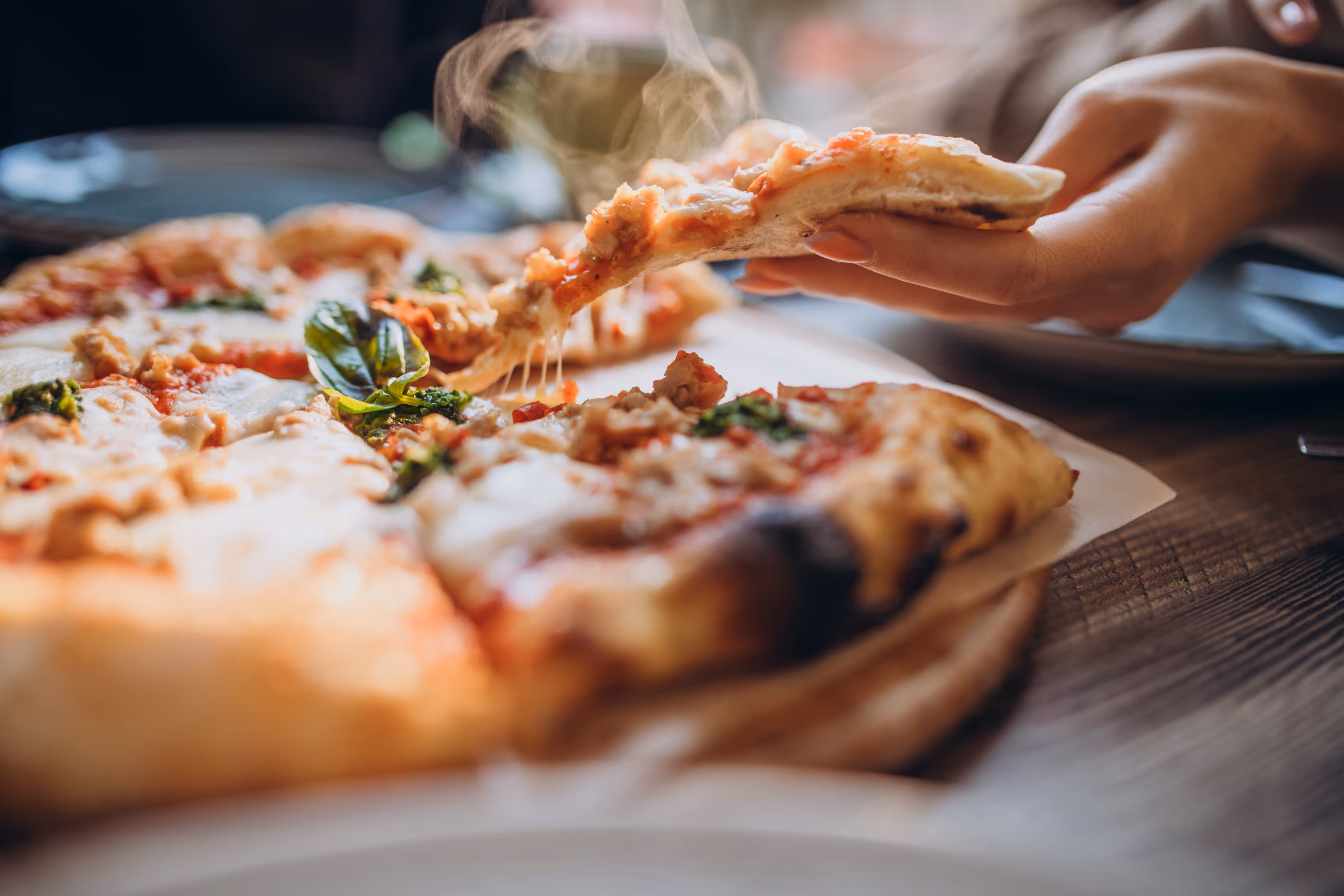 Hand grabbing pizza stock photo