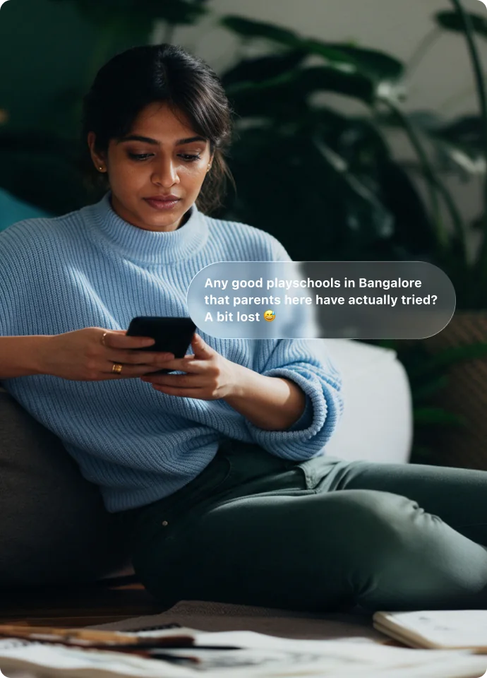 A mother on her phone asking other parents about playschools in Bangalore