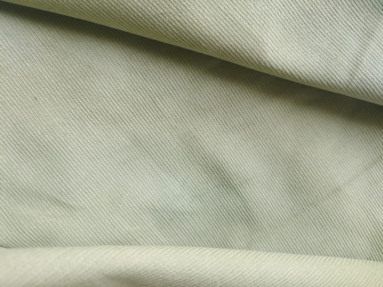 Close-up of soft, wrinkled pink cotton fabric displaying fine weave texture.