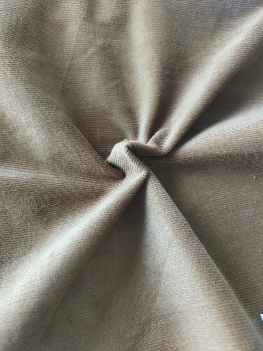 Close-up of soft, wrinkled pink cotton fabric displaying fine weave texture.