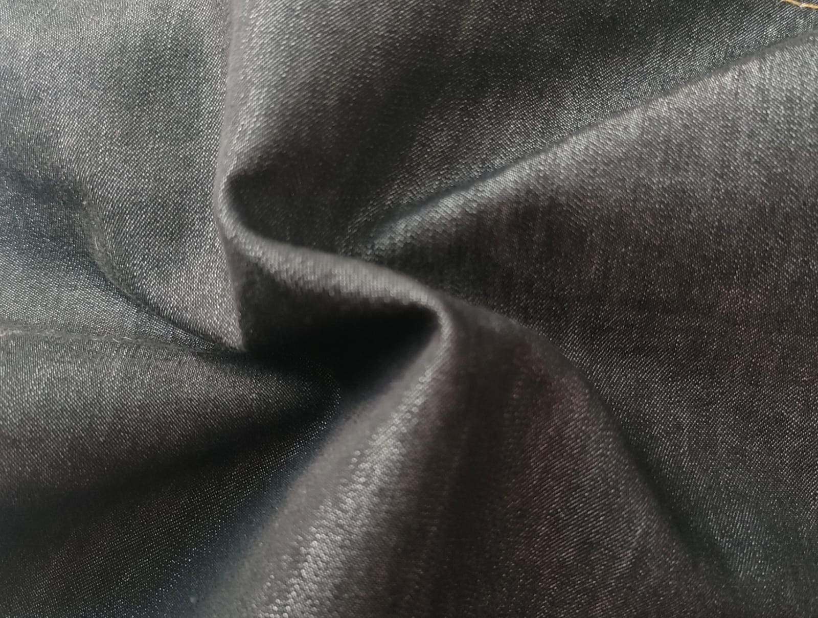 Close-up of soft, wrinkled pink cotton fabric displaying fine weave texture.