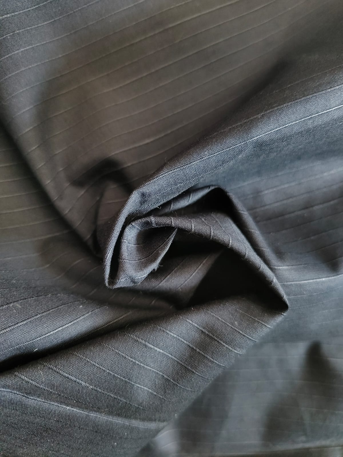 Close-up of soft, wrinkled pink cotton fabric displaying fine weave texture.