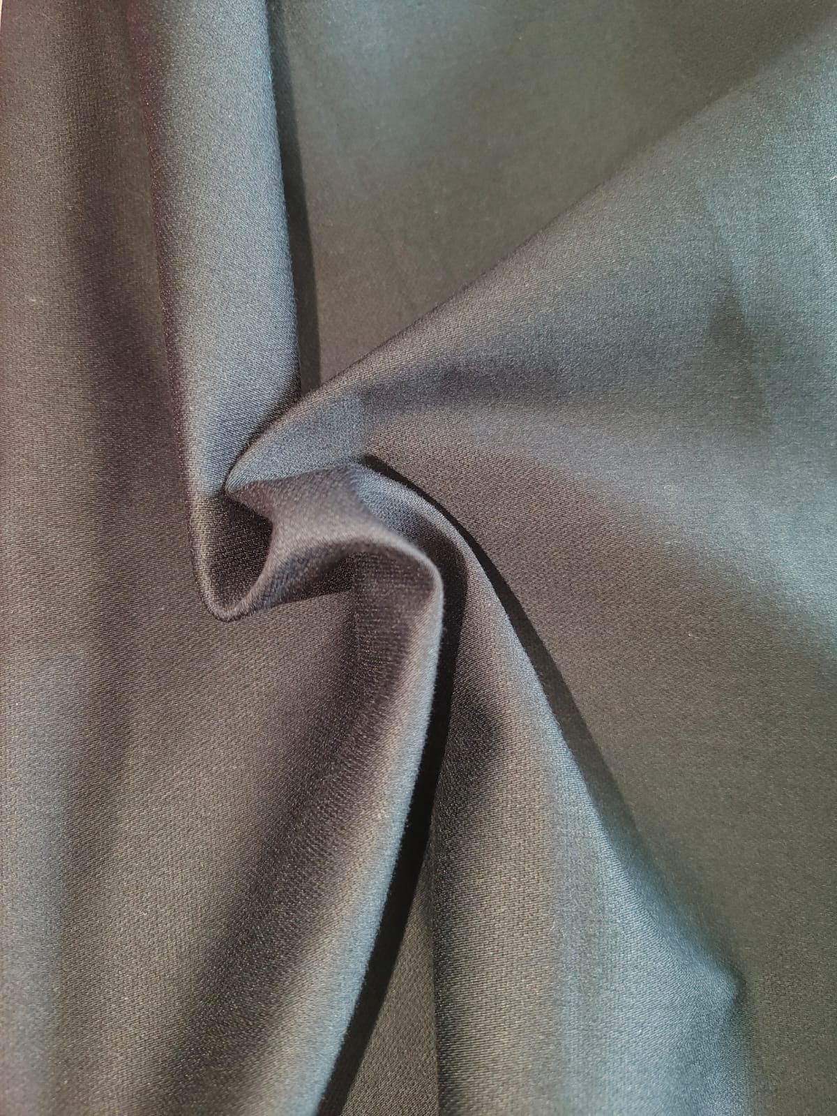 Close-up of soft, wrinkled pink cotton fabric displaying fine weave texture.