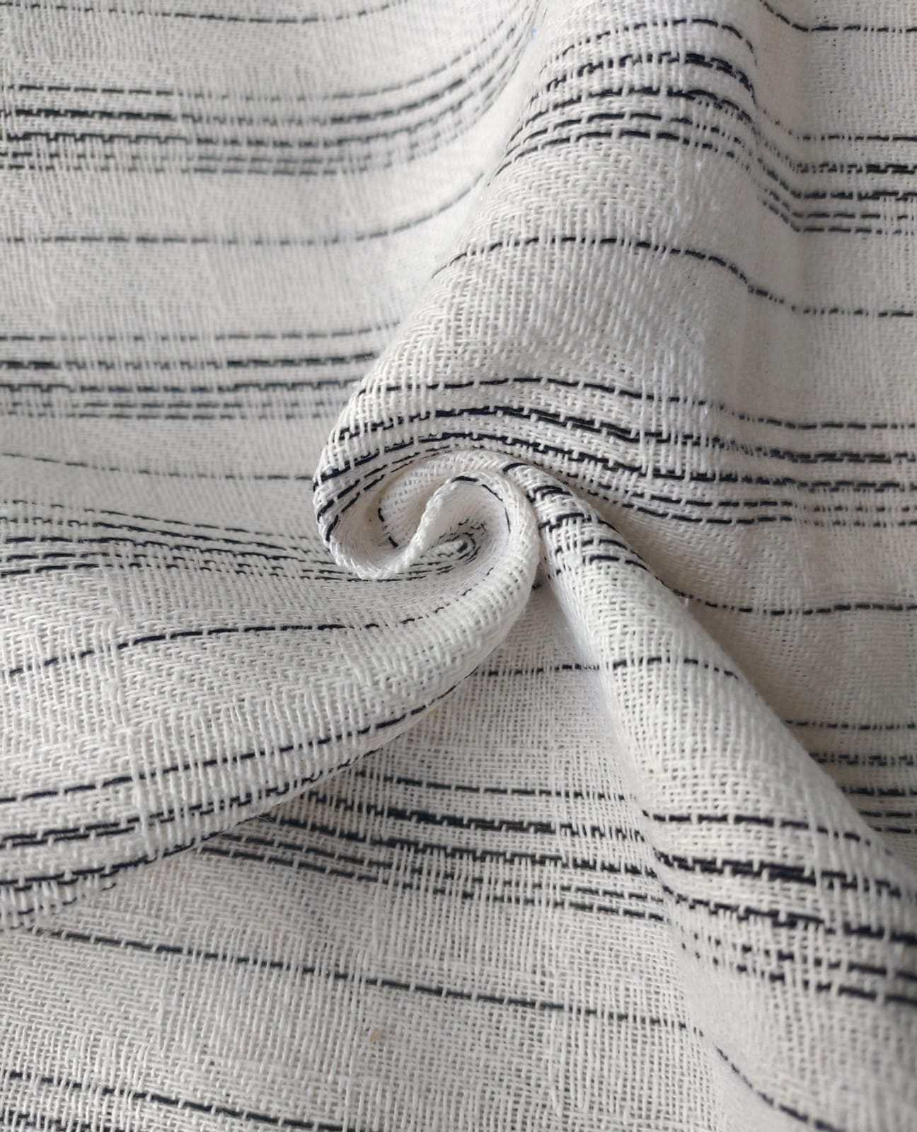 Close-up of soft, wrinkled pink cotton fabric displaying fine weave texture.