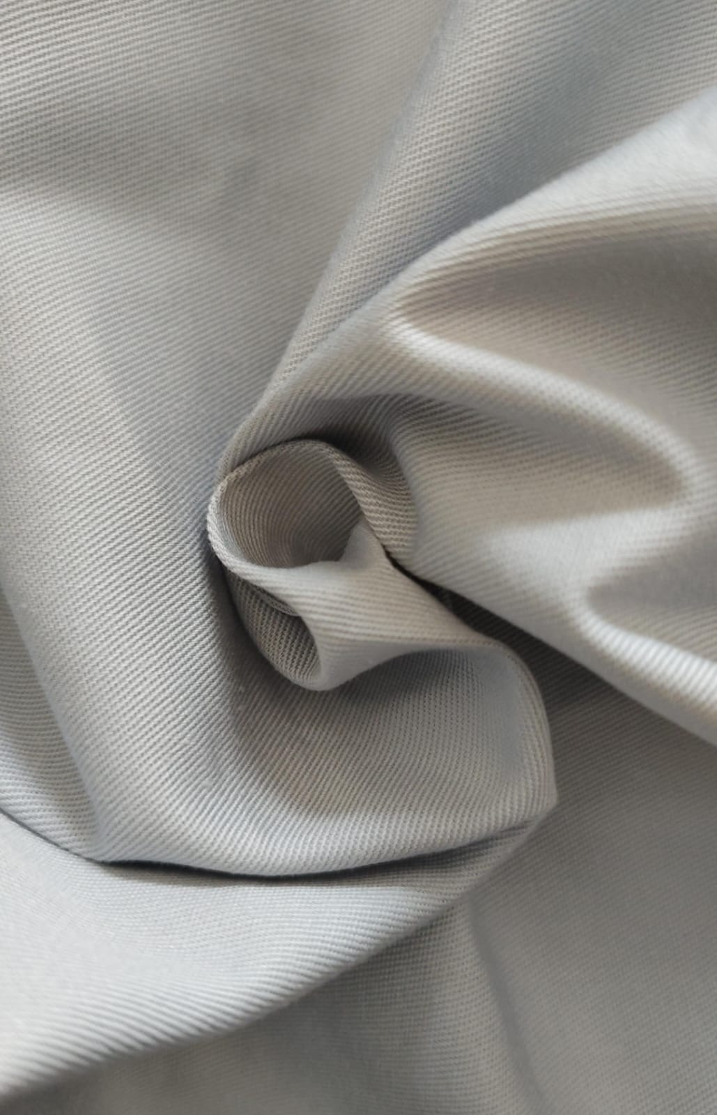 Close-up of soft, wrinkled pink cotton fabric displaying fine weave texture.