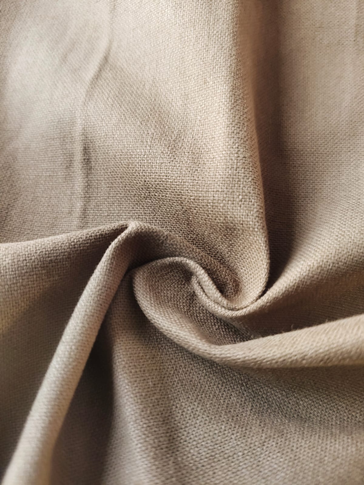 Close-up of soft, wrinkled pink cotton fabric displaying fine weave texture.