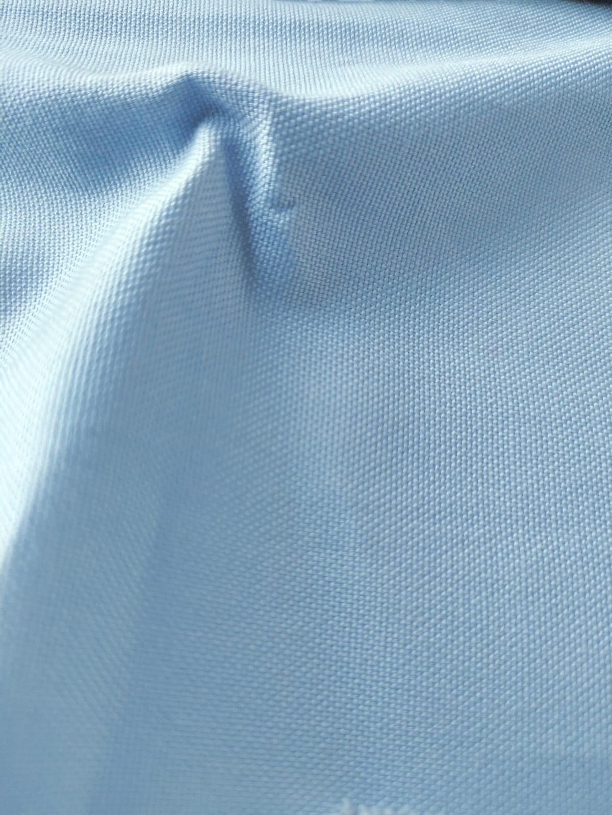 Close-up of soft, wrinkled pink cotton fabric displaying fine weave texture.