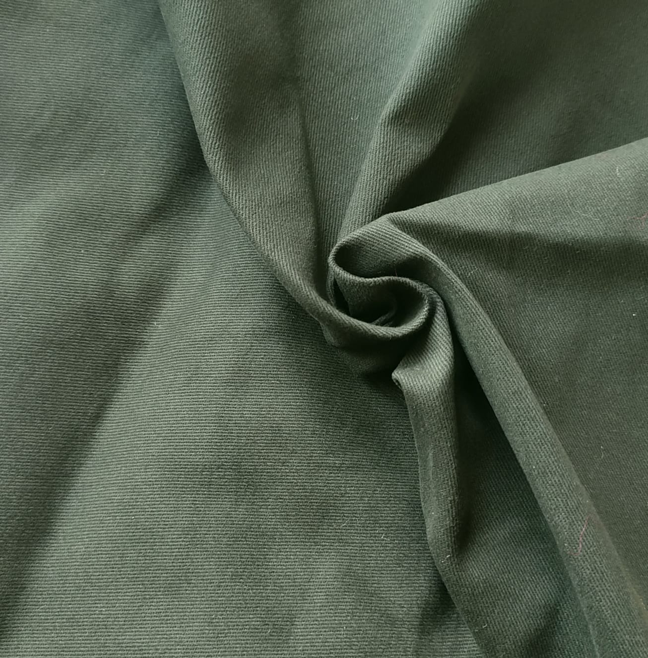 Close-up of soft, wrinkled pink cotton fabric displaying fine weave texture.