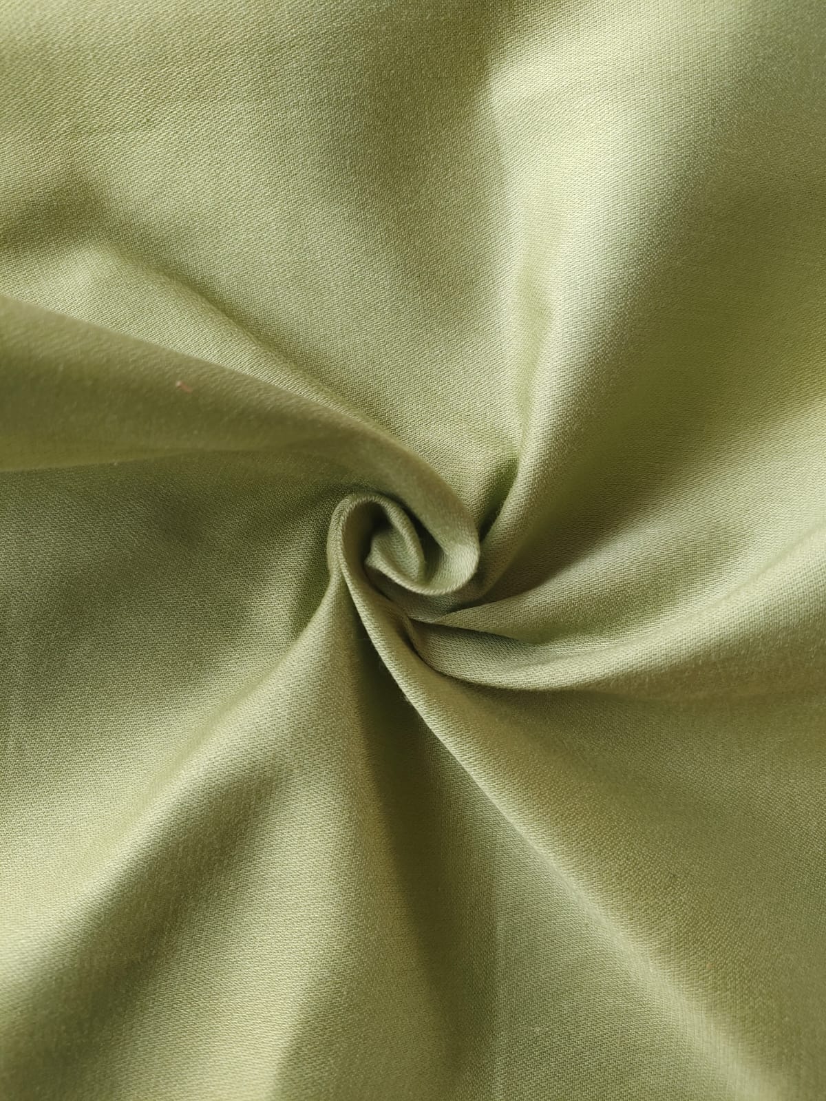 Close-up of soft, wrinkled pink cotton fabric displaying fine weave texture.