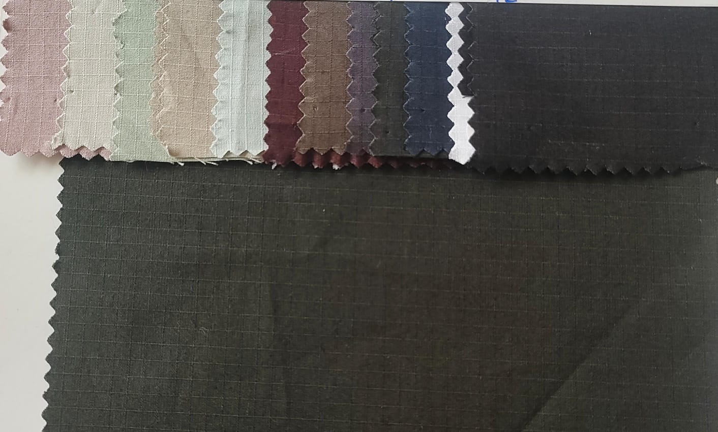 Close-up of soft, wrinkled pink cotton fabric displaying fine weave texture.