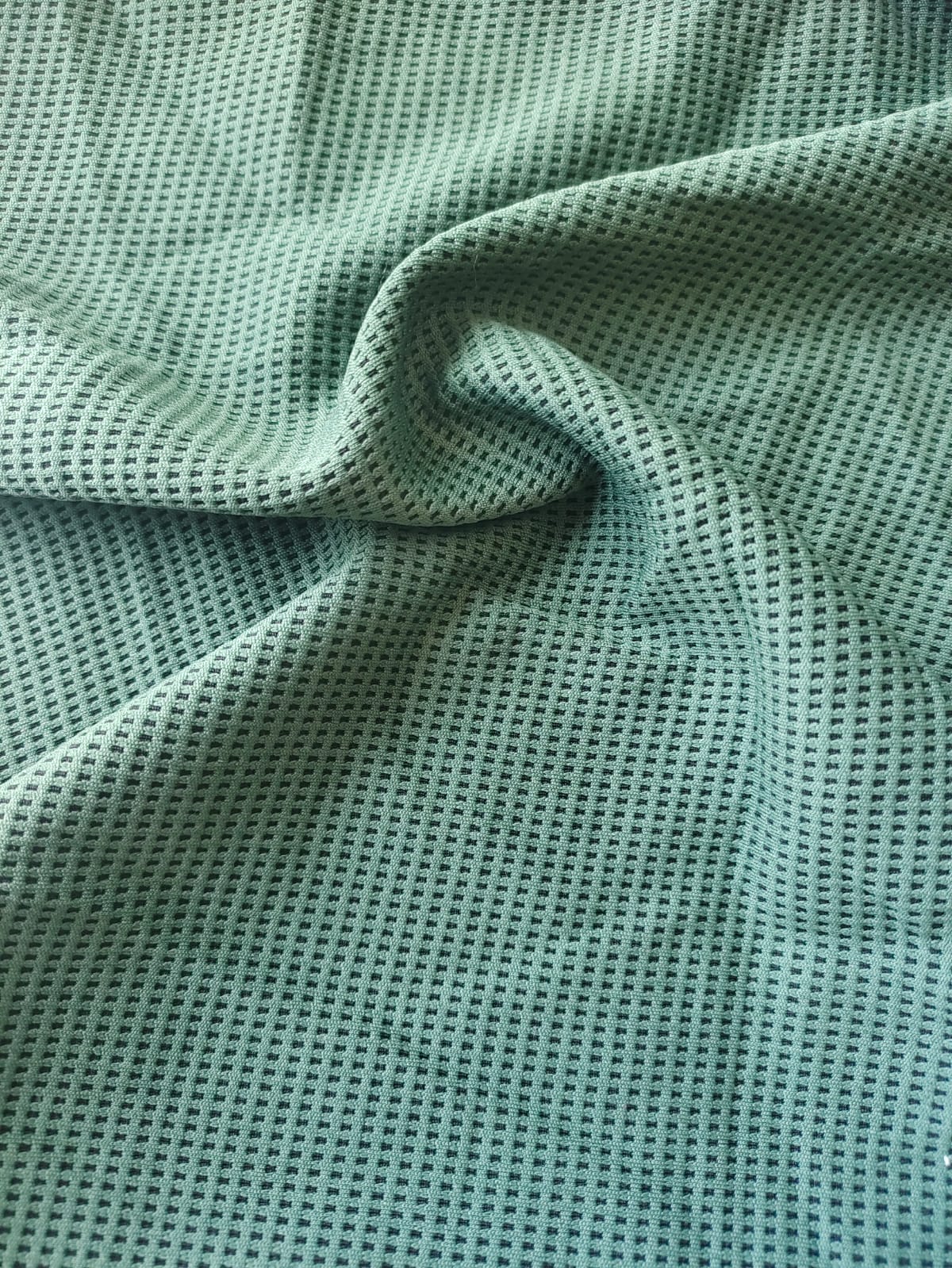 Close-up of soft, wrinkled pink cotton fabric displaying fine weave texture.