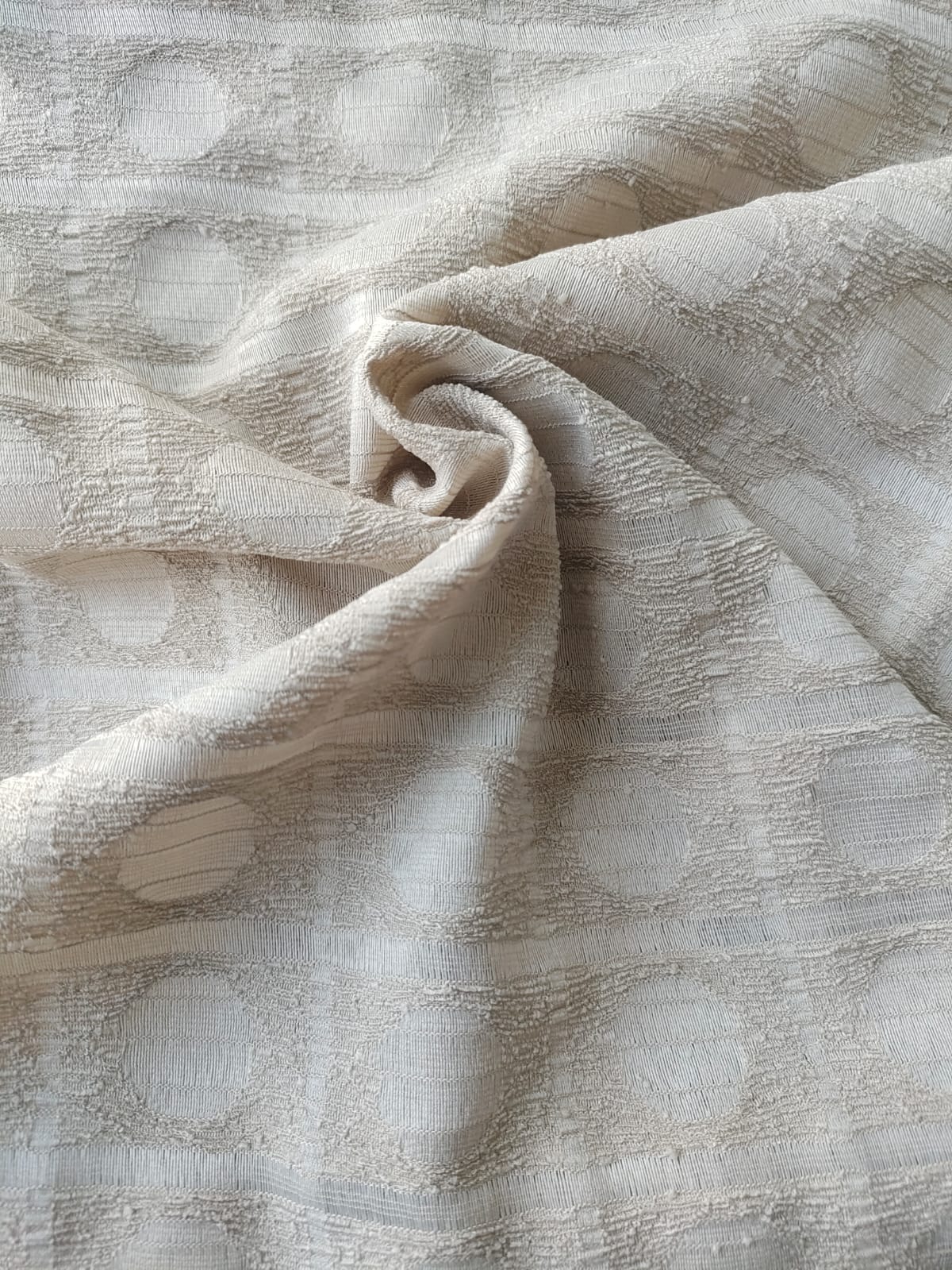 Close-up of soft, wrinkled pink cotton fabric displaying fine weave texture.
