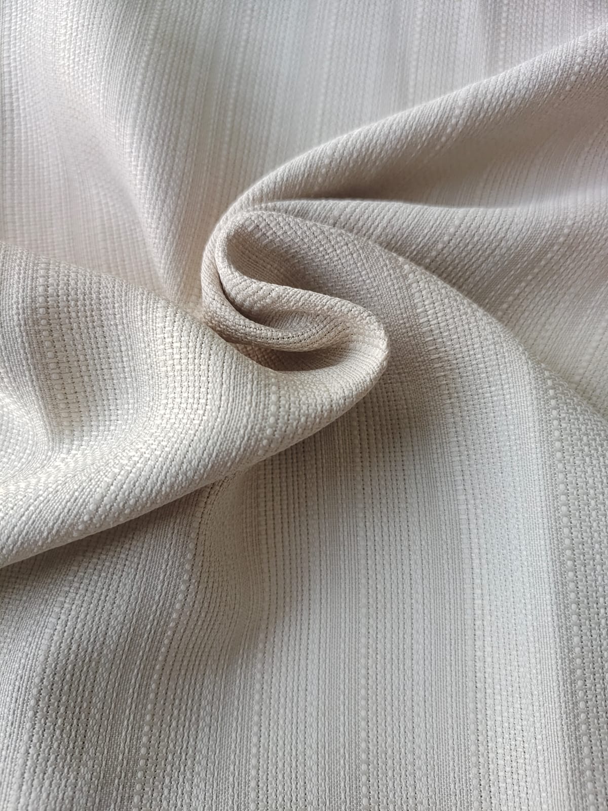 Close-up of soft, wrinkled pink cotton fabric displaying fine weave texture.