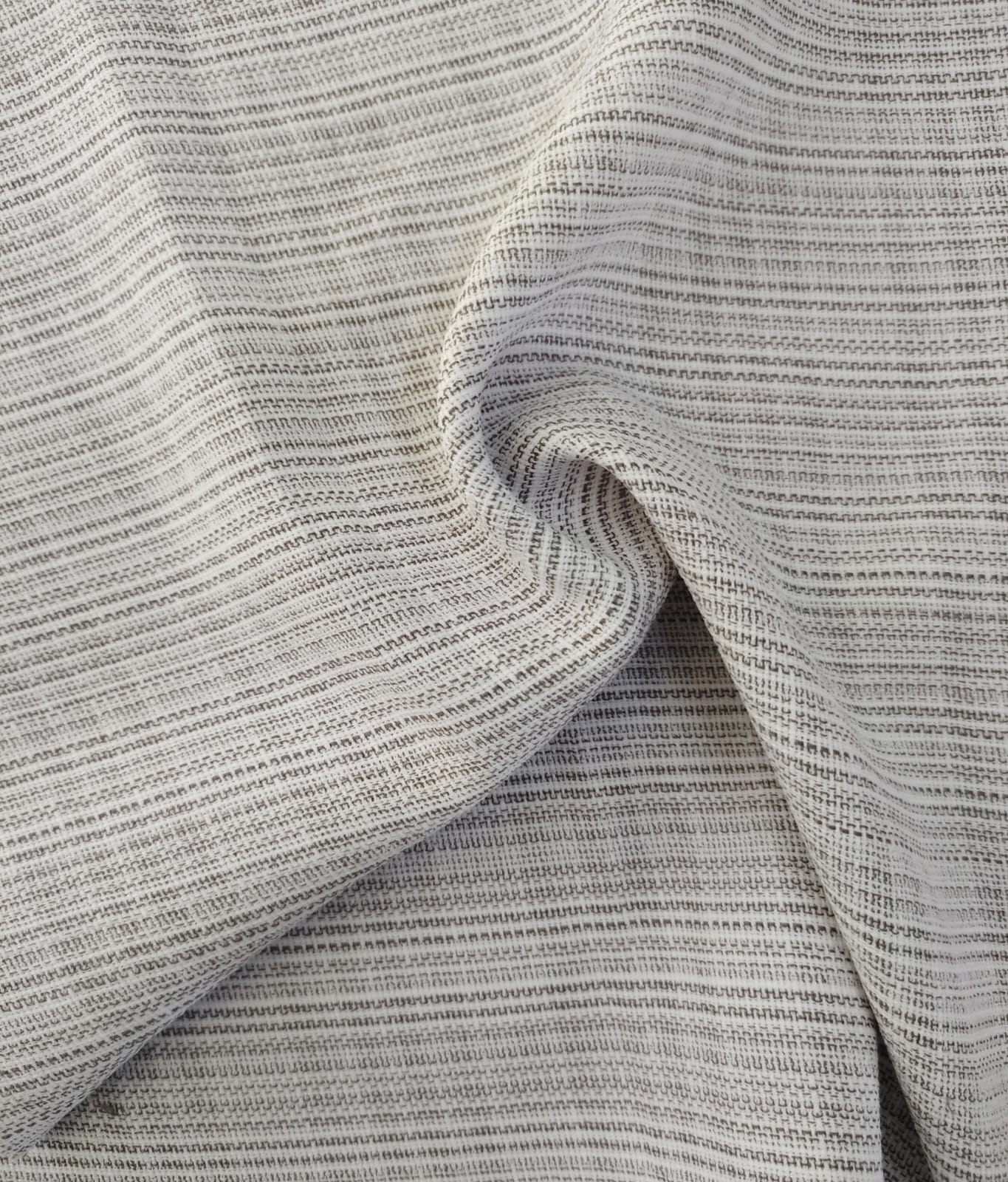 Close-up of soft, wrinkled pink cotton fabric displaying fine weave texture.