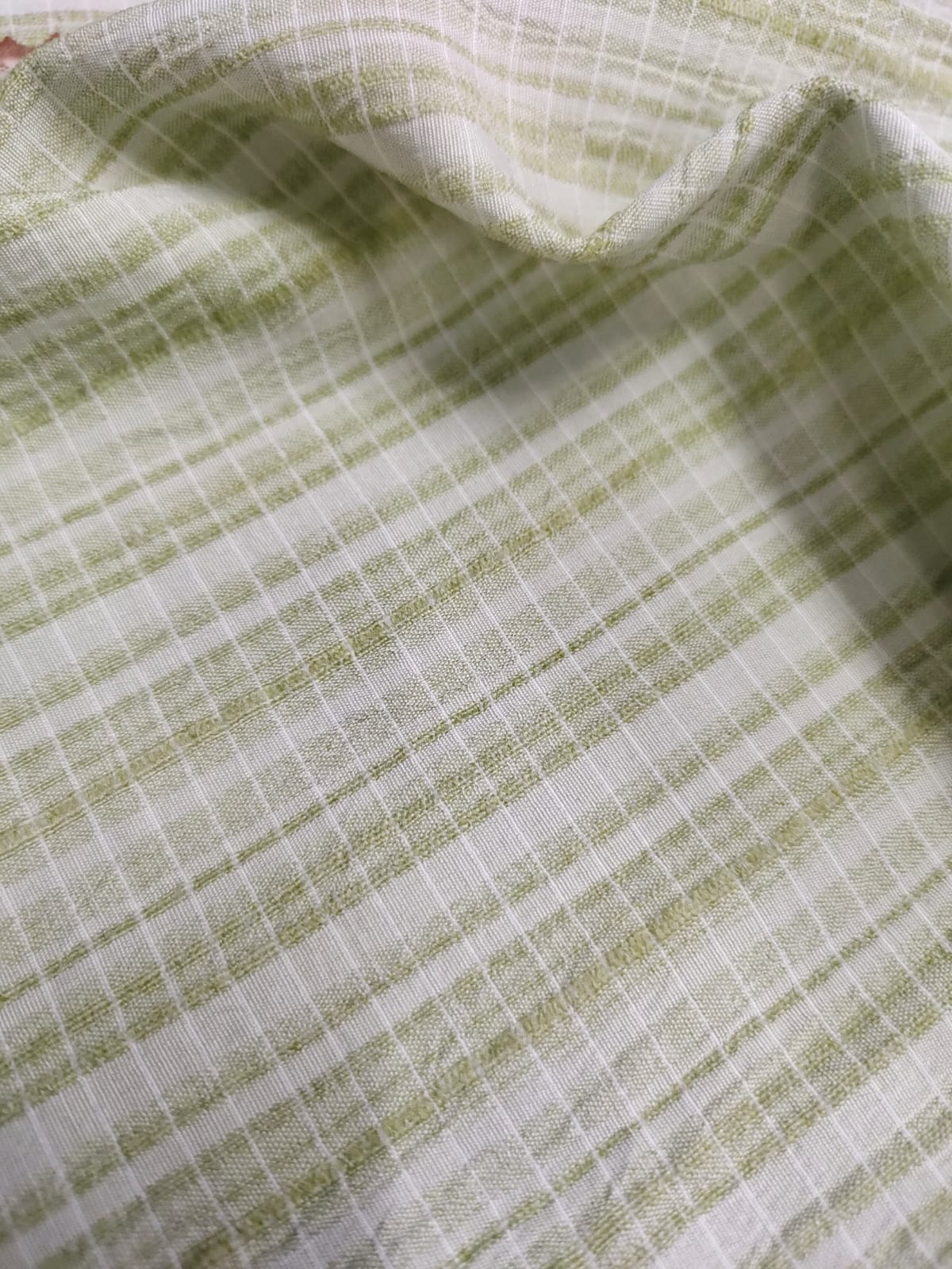 Close-up of soft, wrinkled pink cotton fabric displaying fine weave texture.