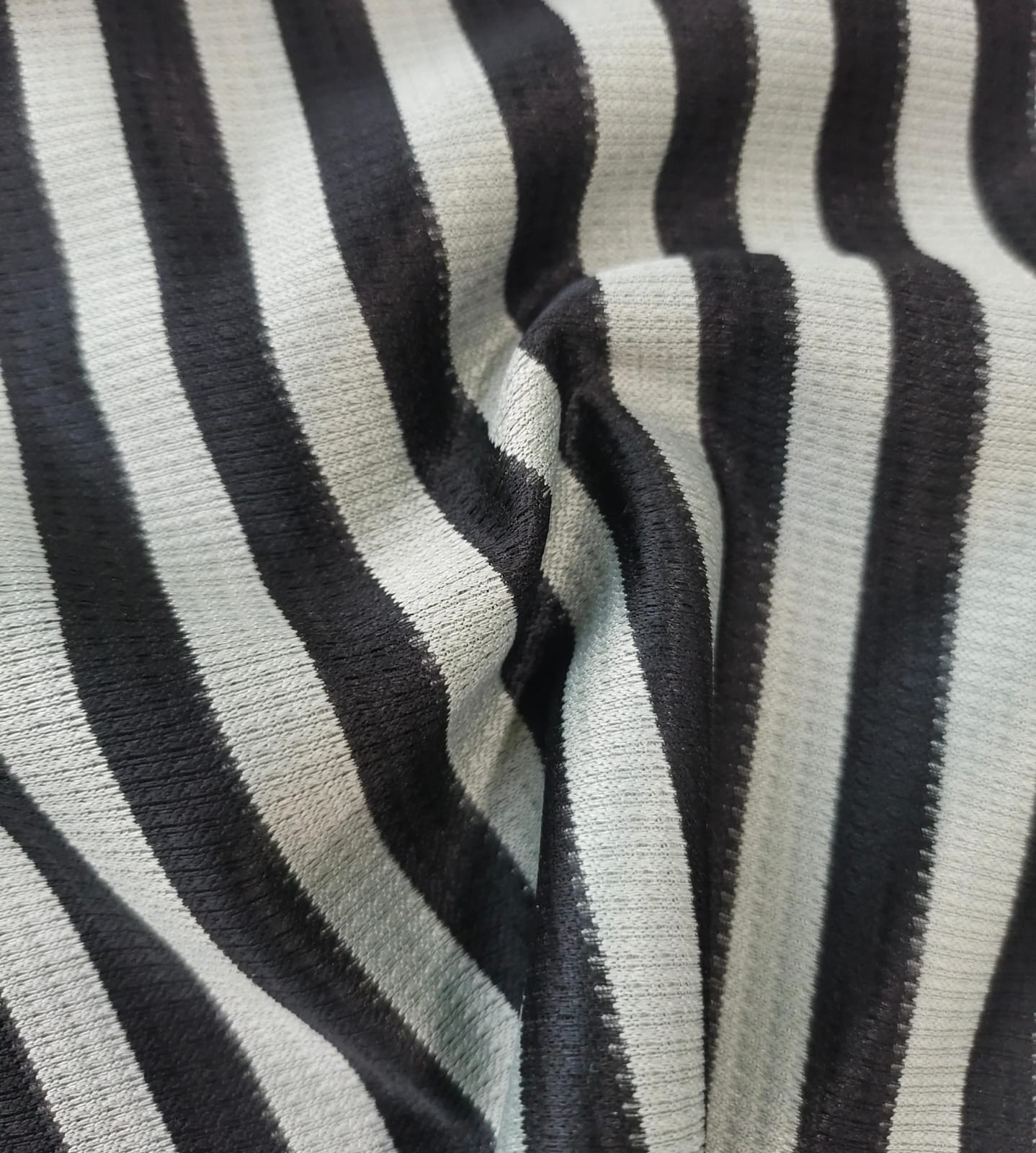 Close-up of soft, wrinkled pink cotton fabric displaying fine weave texture.