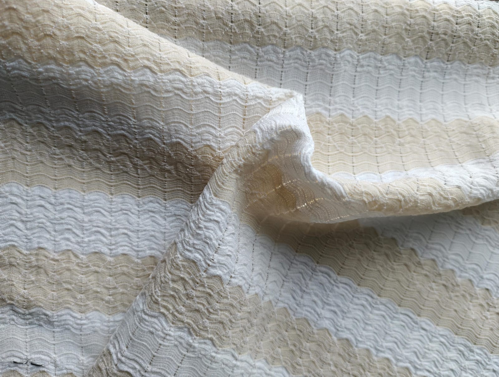 Close-up of soft, wrinkled pink cotton fabric displaying fine weave texture.
