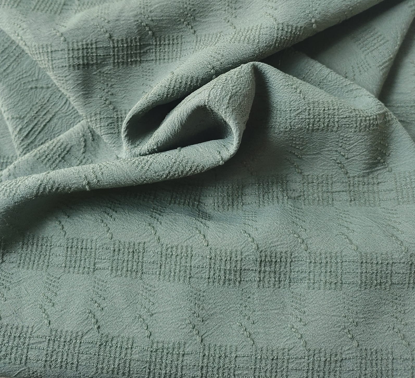 Close-up of soft, wrinkled pink cotton fabric displaying fine weave texture.