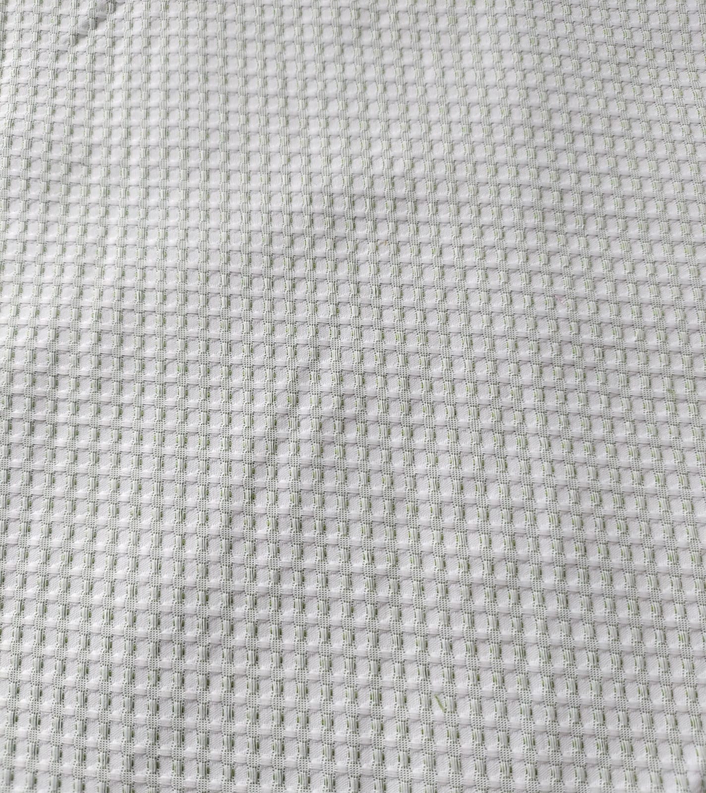 Close-up of soft, wrinkled pink cotton fabric displaying fine weave texture.