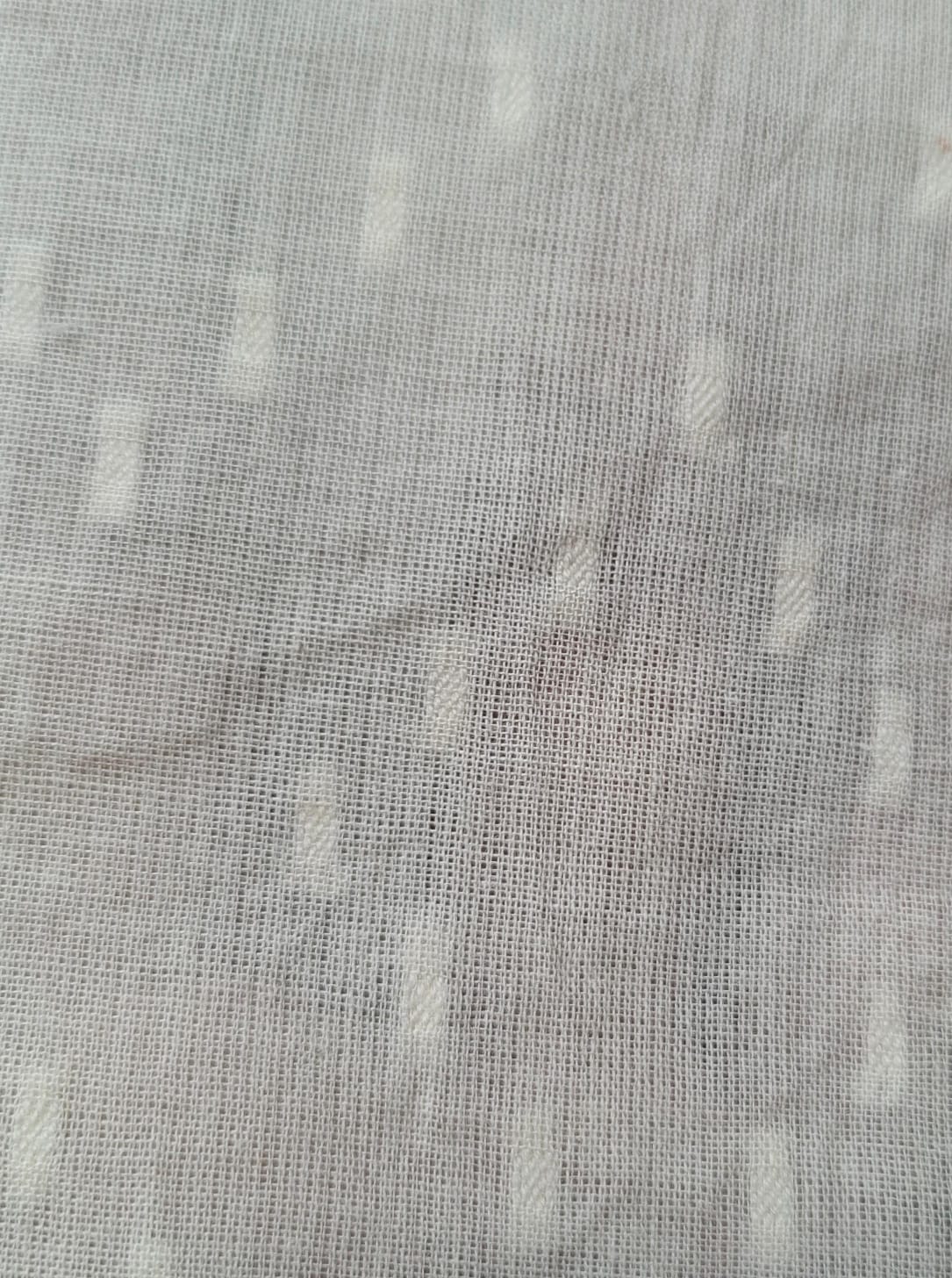 Close-up of soft, wrinkled pink cotton fabric displaying fine weave texture.