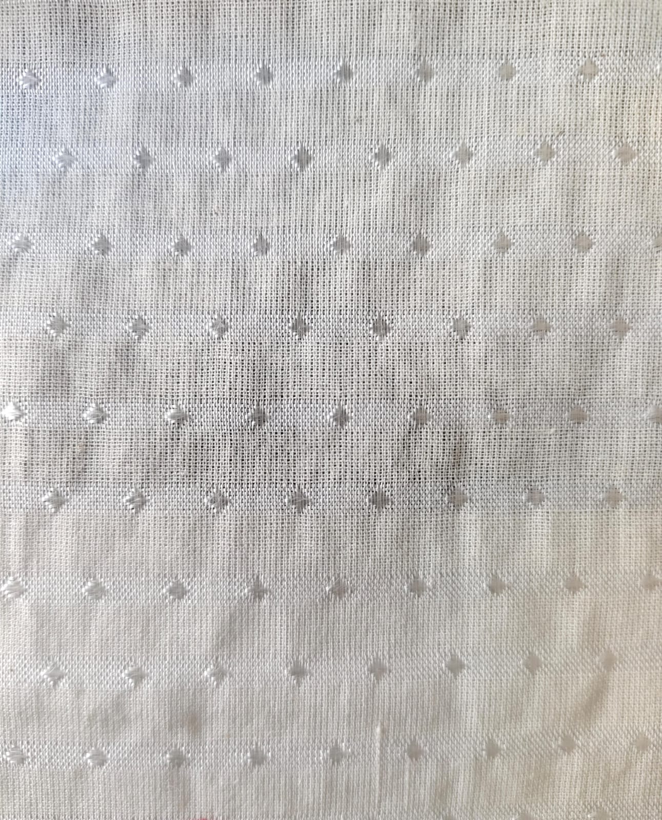 Close-up of soft, wrinkled pink cotton fabric displaying fine weave texture.
