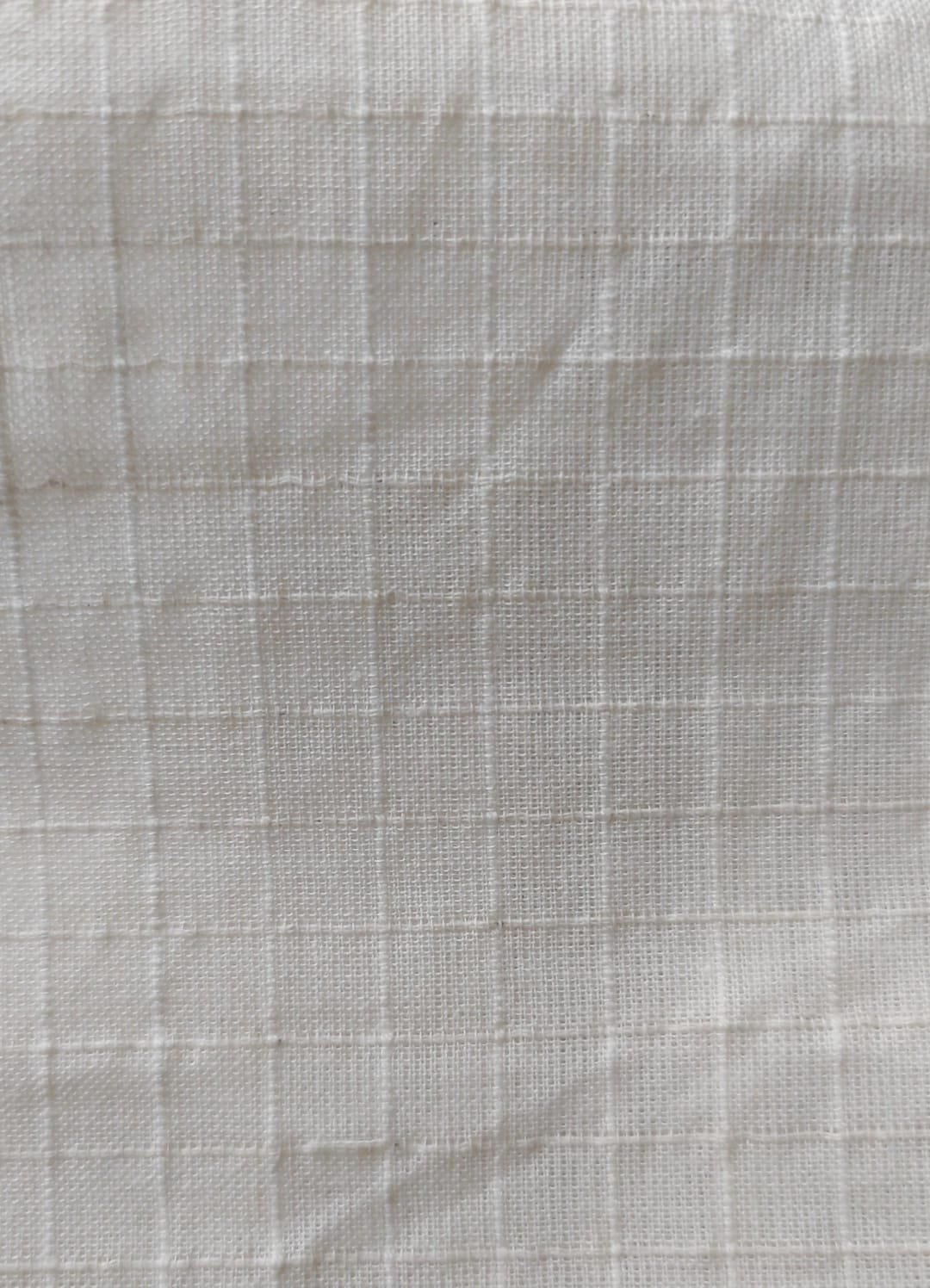 Close-up of soft, wrinkled pink cotton fabric displaying fine weave texture.