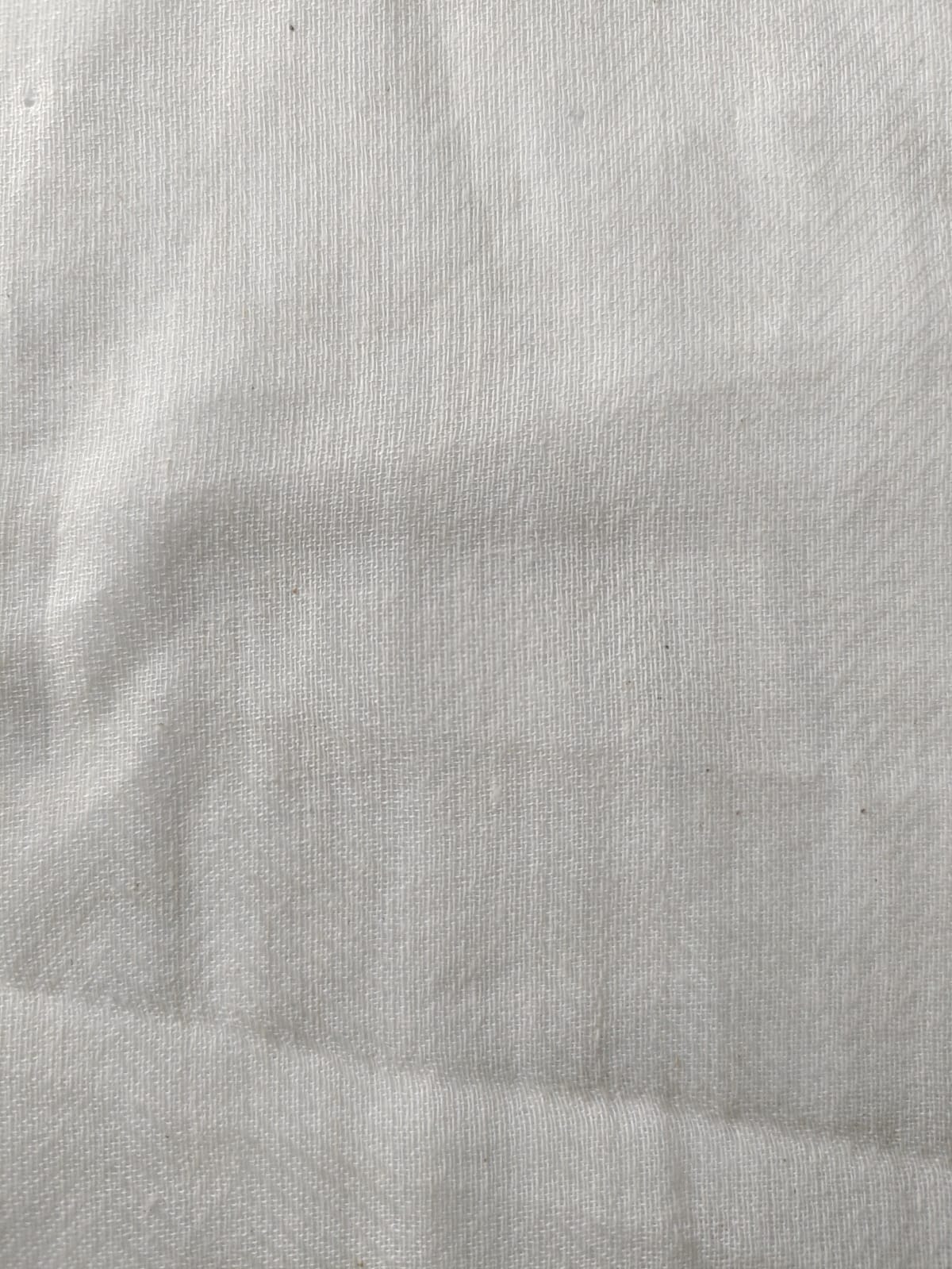 Close-up of soft, wrinkled pink cotton fabric displaying fine weave texture.