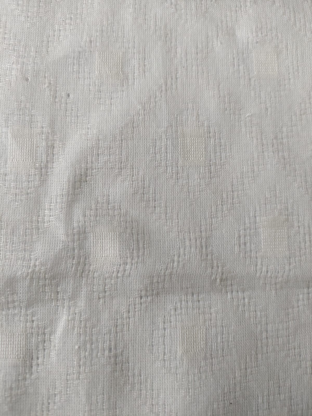 Close-up of soft, wrinkled pink cotton fabric displaying fine weave texture.