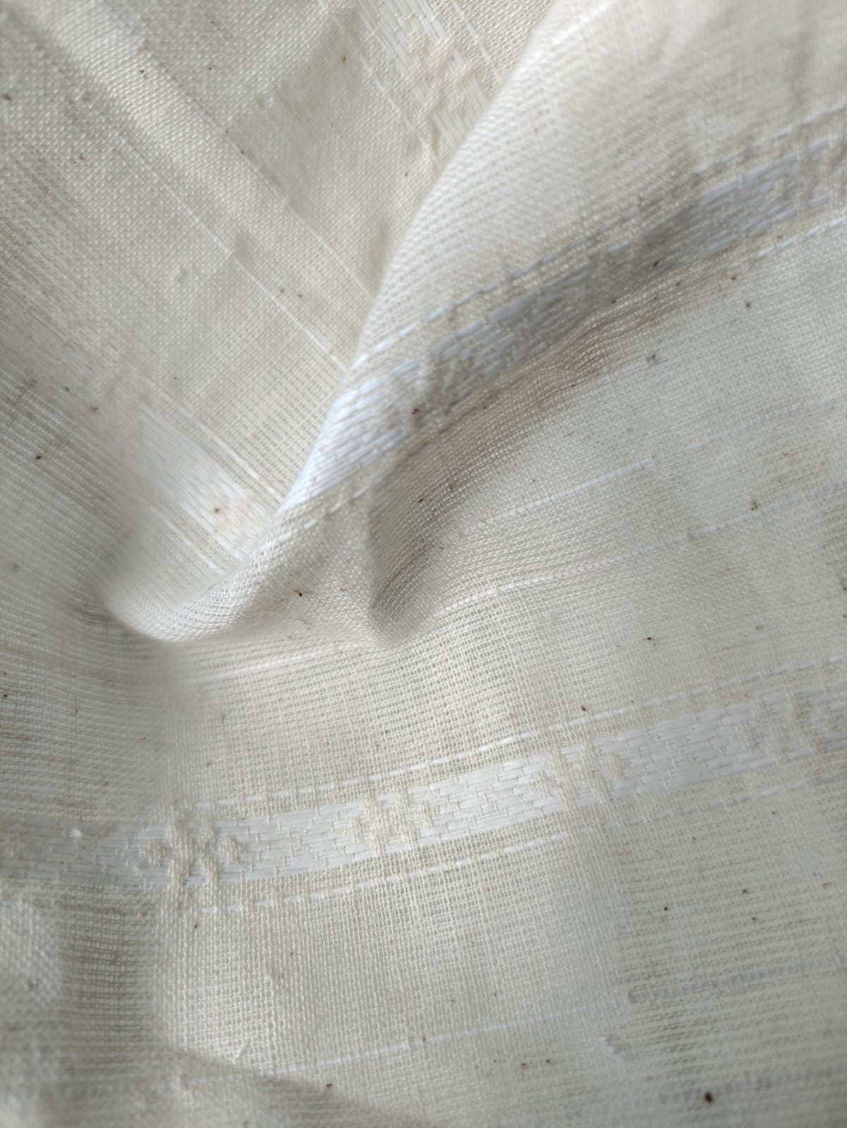 Close-up of soft, wrinkled pink cotton fabric displaying fine weave texture.