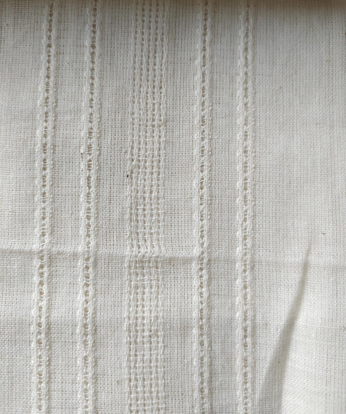 Close-up of soft, wrinkled pink cotton fabric displaying fine weave texture.