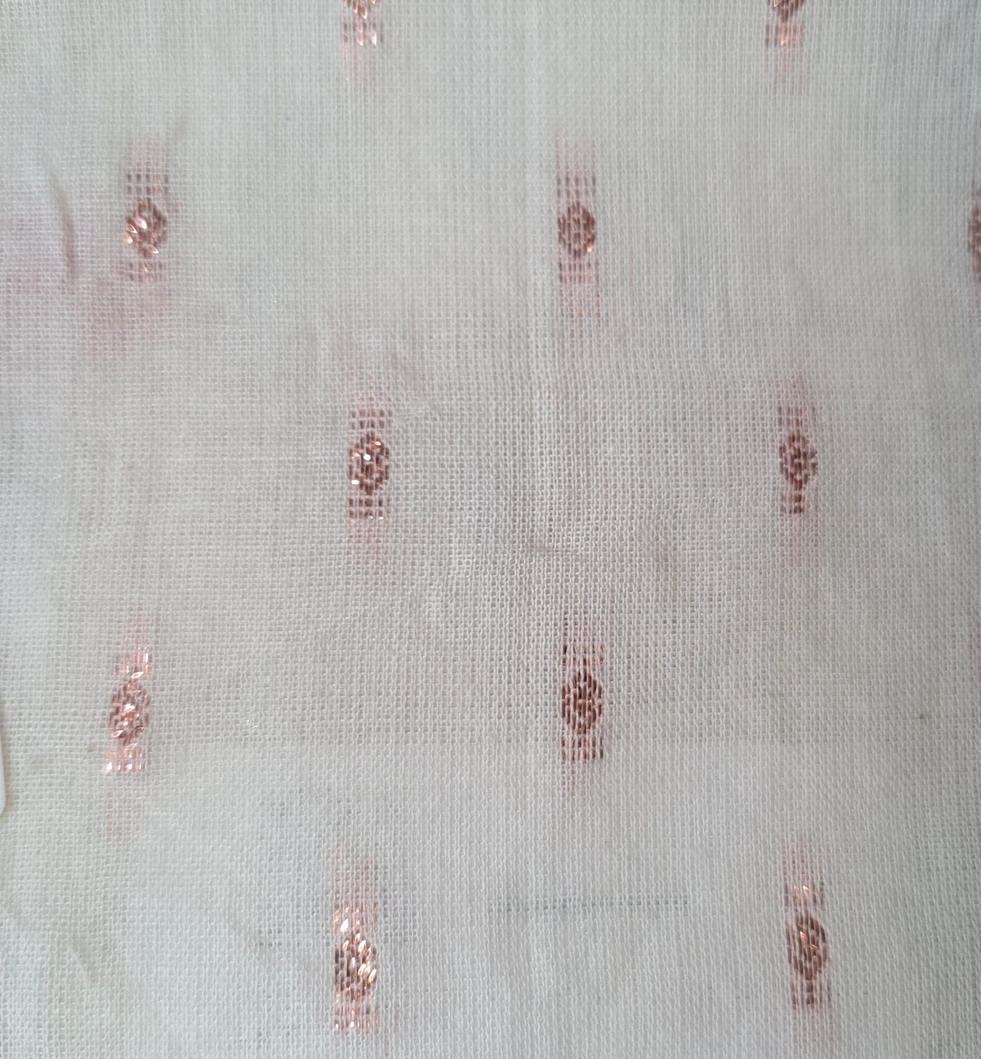 Close-up of soft, wrinkled pink cotton fabric displaying fine weave texture.
