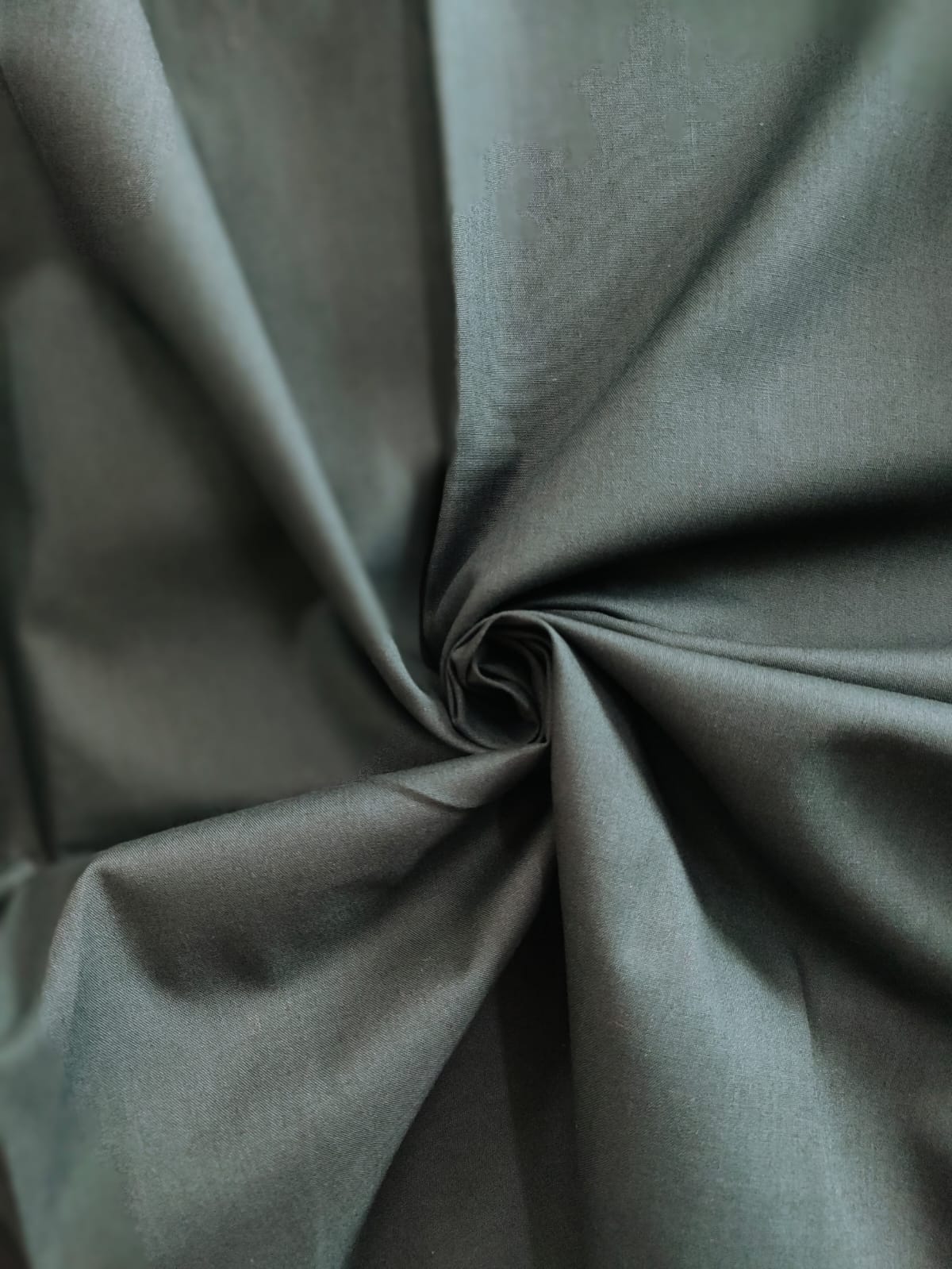 Close-up of soft, wrinkled pink cotton fabric displaying fine weave texture.