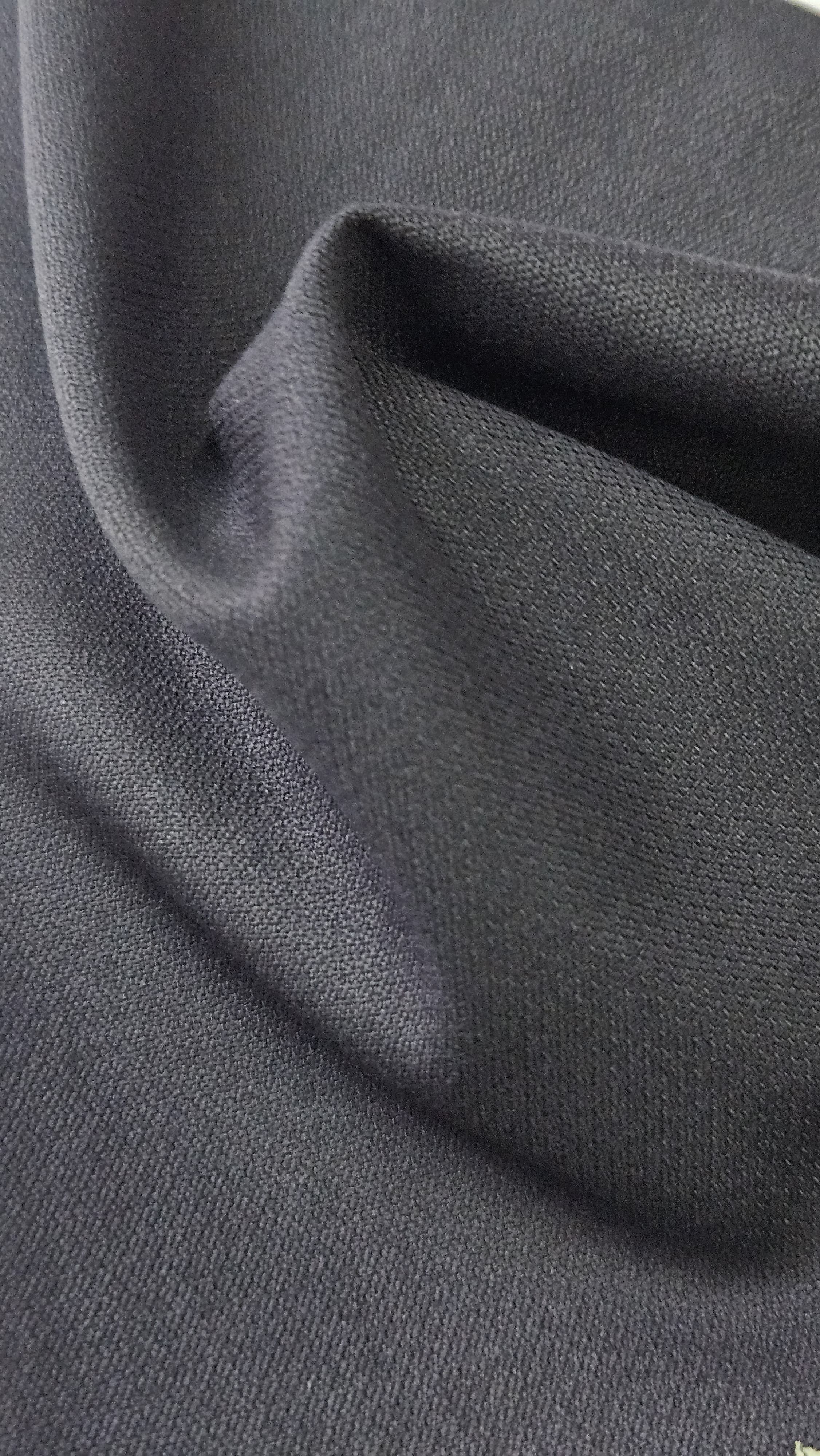 Close-up of soft, wrinkled pink cotton fabric displaying fine weave texture.