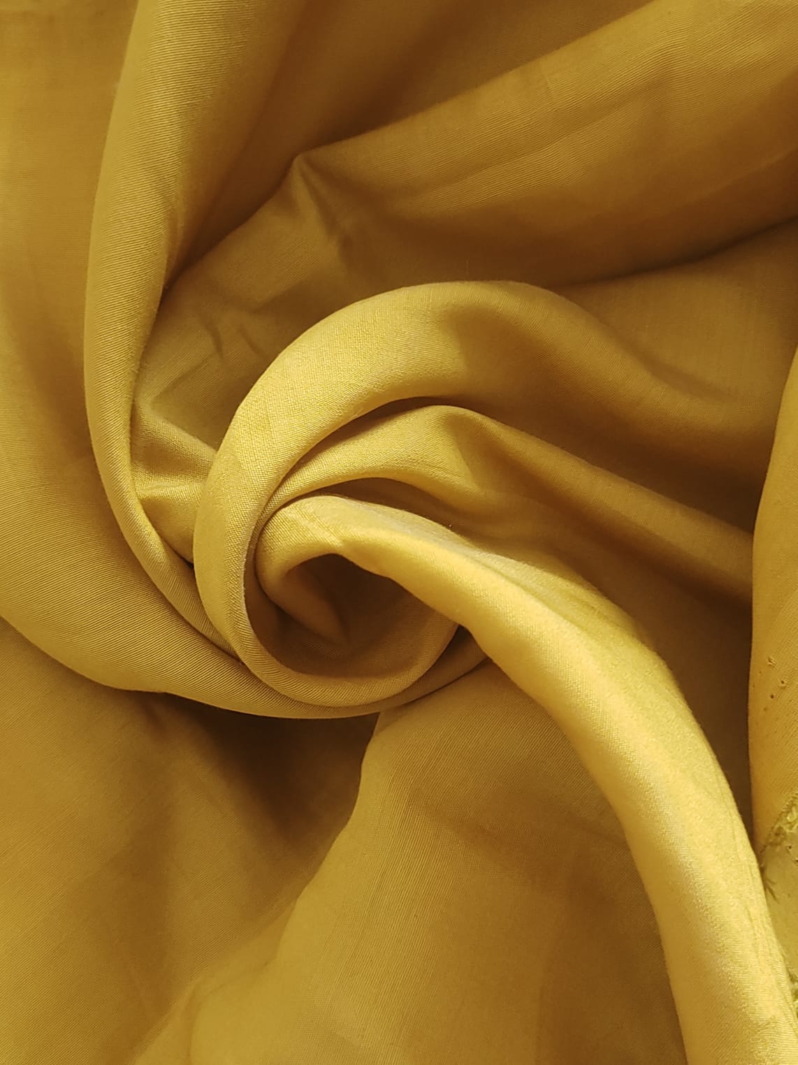 Close-up of soft, wrinkled pink cotton fabric displaying fine weave texture.