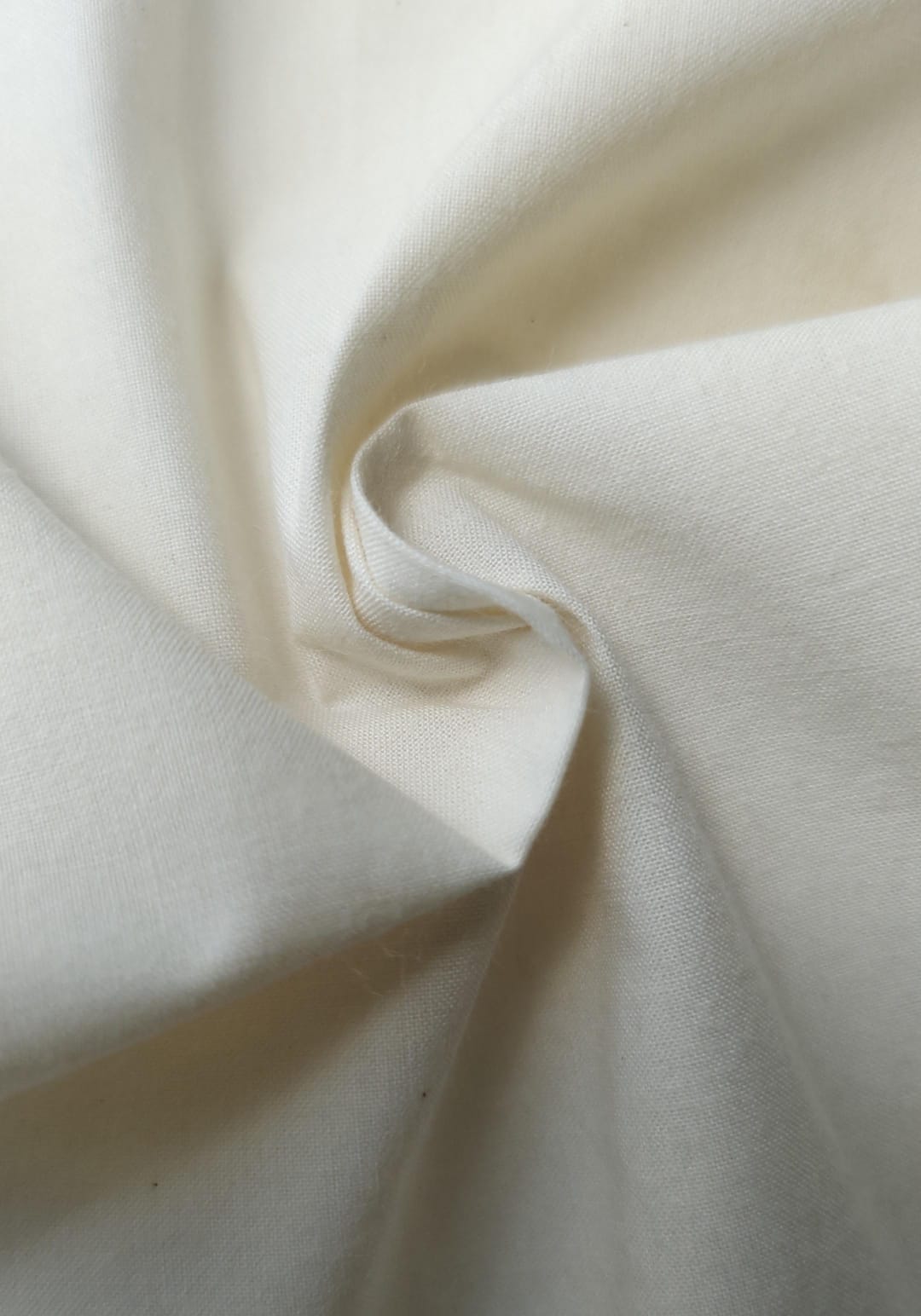 Close-up of soft, wrinkled pink cotton fabric displaying fine weave texture.