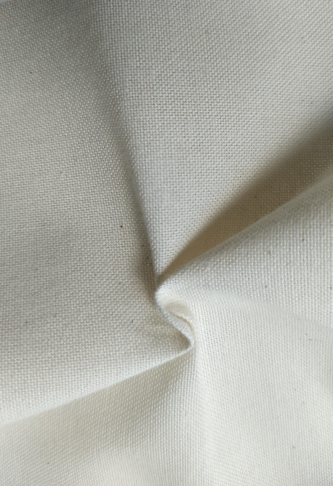 Close-up of soft, wrinkled pink cotton fabric displaying fine weave texture.