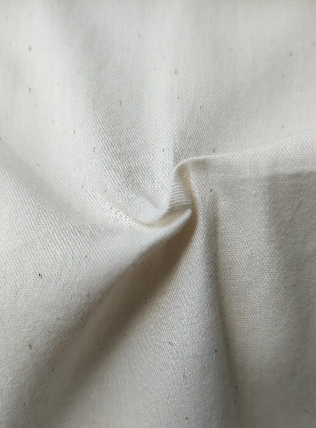 Close-up of soft, wrinkled pink cotton fabric displaying fine weave texture.