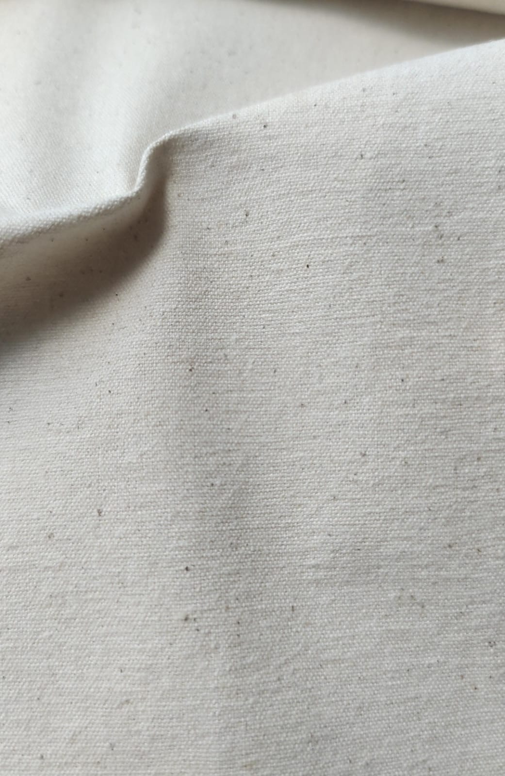 Close-up of soft, wrinkled pink cotton fabric displaying fine weave texture.